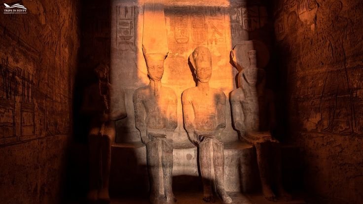 Sunlight illuminating statues of Ramses II and deities inside the sanctuary of Abu Simbel Temple during solar alignment.